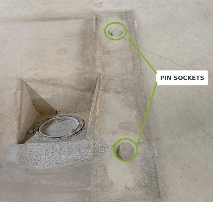 Two cast locating-pin sockets in a precast tunnel segment near the spacer bearing area.