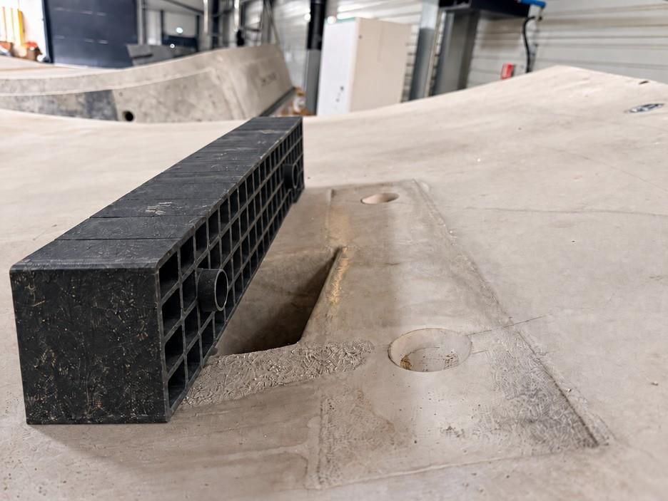 Green Spacer in recycled plastic beside the positioning pin sockets in a precast concrete tunnel segment