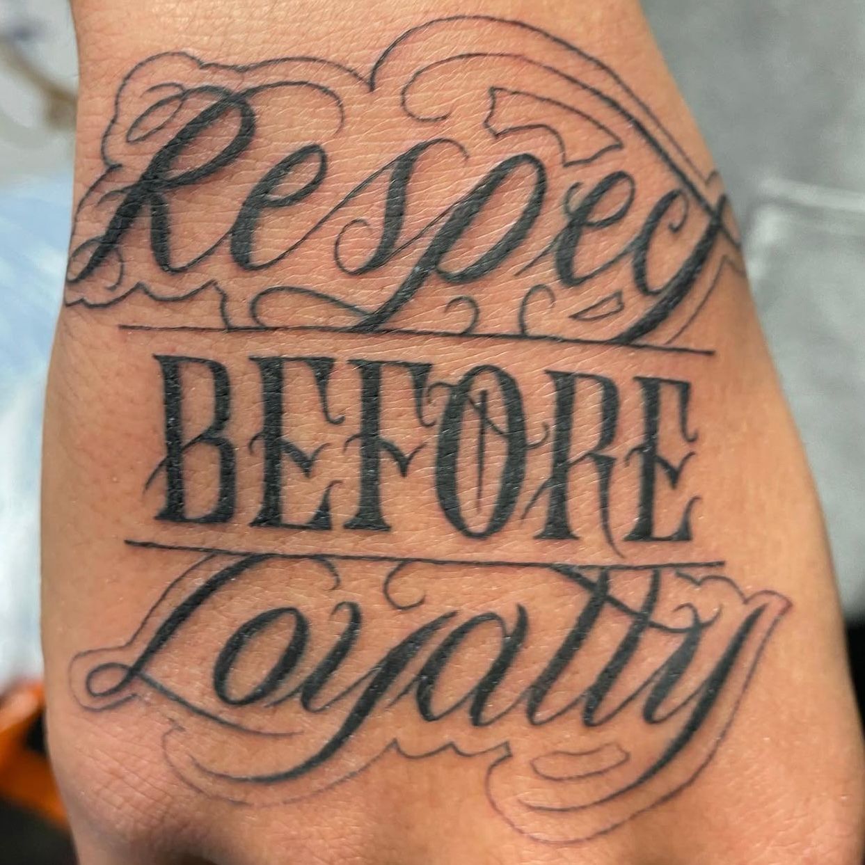 Tattoo on a hand. Text reads 