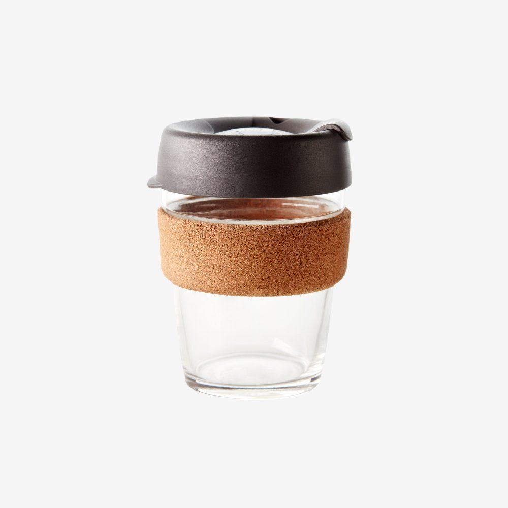 Reusable glass coffee cup with cork sleeve and black lid.