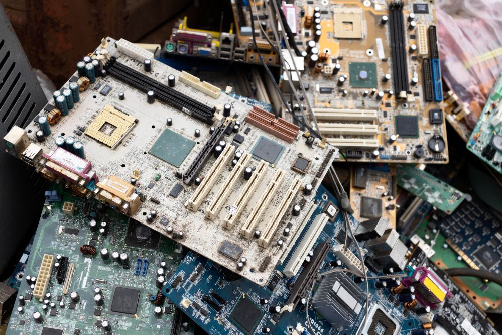 A pile of computer parts including a motherboard sitting on top of each other.