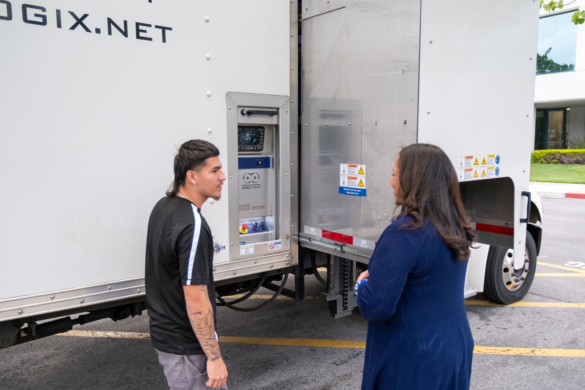 A man and a woman are standing in front of a truck.