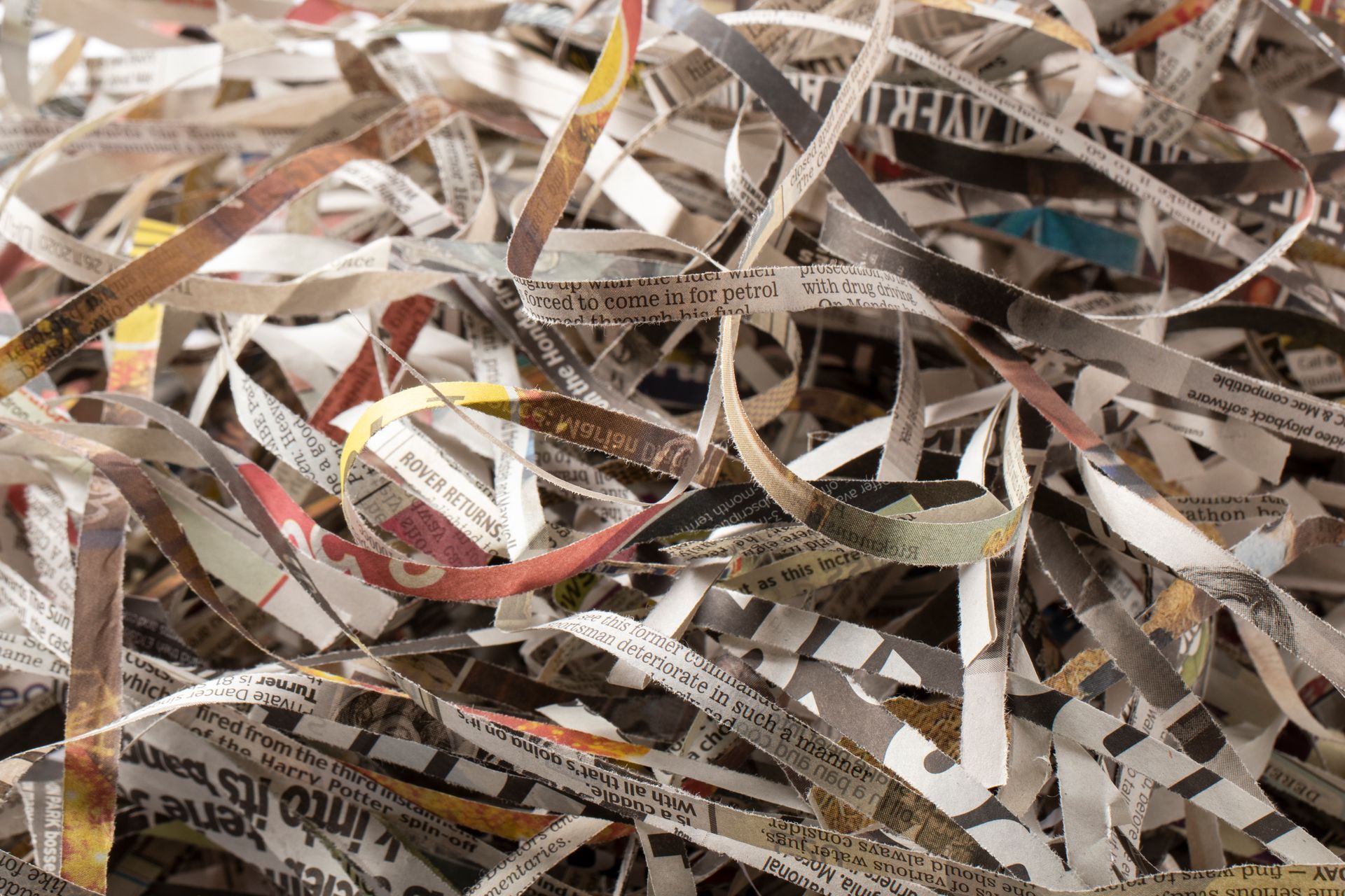Shredded newspaper strips, some with visible text, piled together.