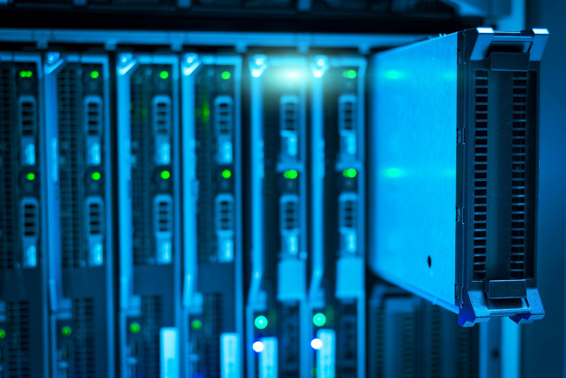A blade server being pulled out of a blue-lit data center rack.