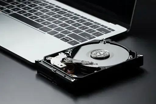 Hard drive vs paper shredding concept with laptop and open hard drive