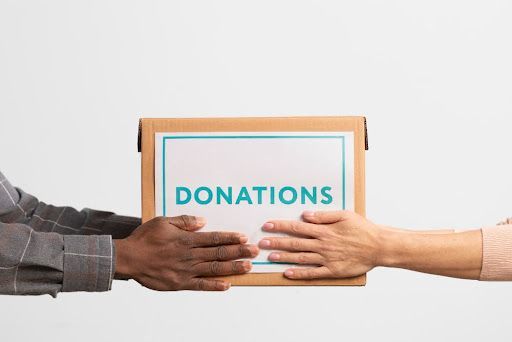 Two people exchanging a donation box, symbolizing secure Santa Rosa donor data shredding services.