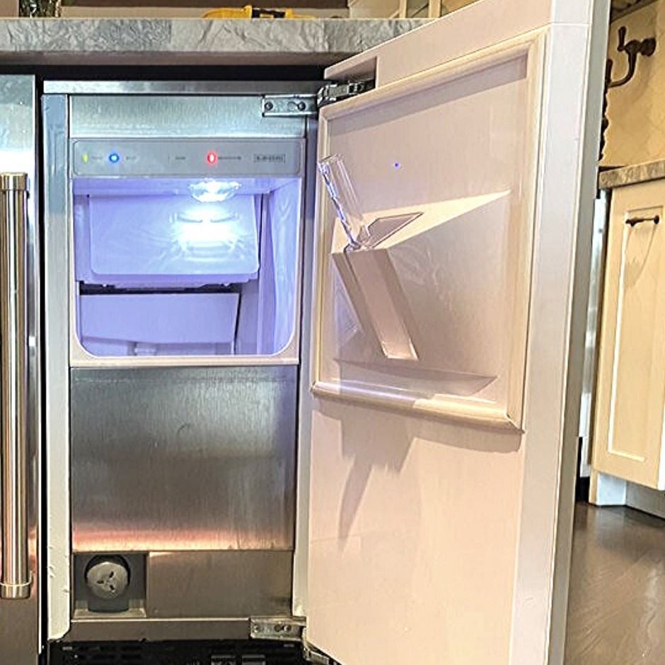 Open freezer compartment inside a stainless steel refrigerator, lit from within.