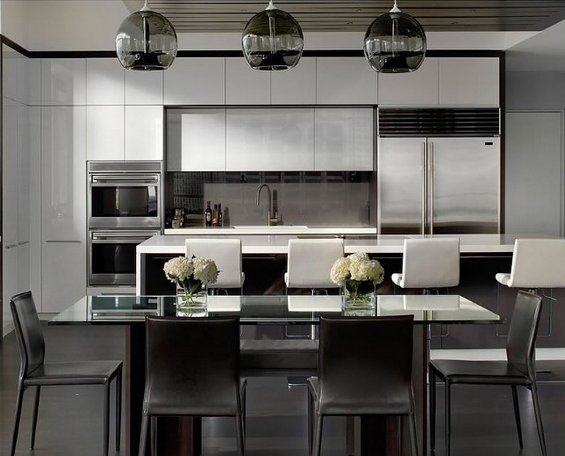 Modern black-and-white kitchen with island, pendant lights, and dining stools