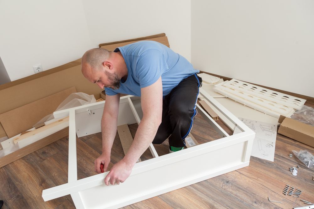 Man Assembling Furniture in a Room — Roll Edge In Manunda, QLD