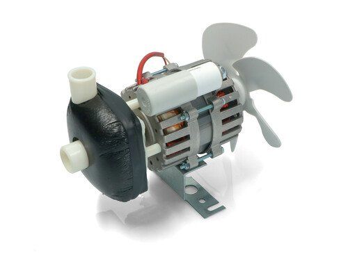 Piccola pompa elettrica con involucro nero, motore argentato e pale del ventilatore in plastica bianca su una staffa metallica.