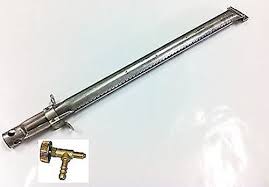 Lungo tubo metallico con una piccola valvola in ottone inserita su sfondo bianco.