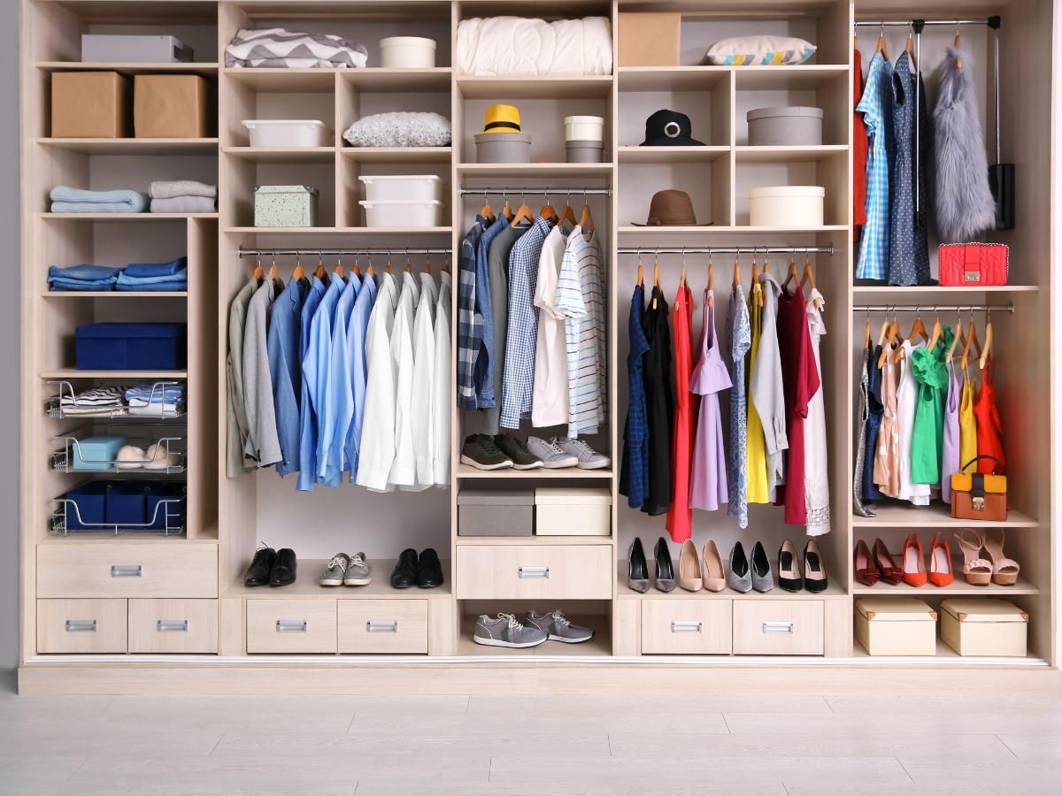 Example of a full-width fitted wardrobe with hanging rails, open shelving, shoe racks and drawers