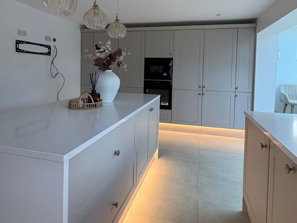 Completed kitchen installation in Spondon with grey shaker units, white quartz island and LED plinth lighting