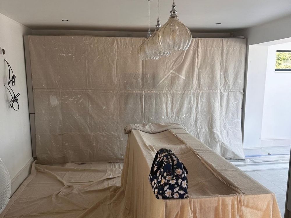 Kitchen units protected under dust sheets during installation in Spondon with pendant lights already fitted