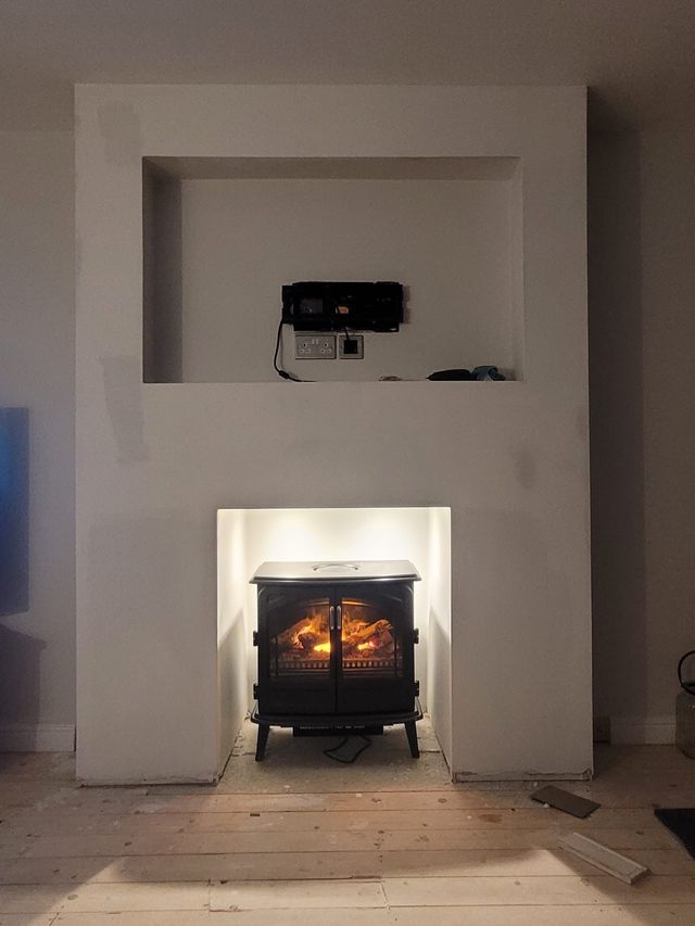 Finished media wall with a stove-style fire and a recess for the TV