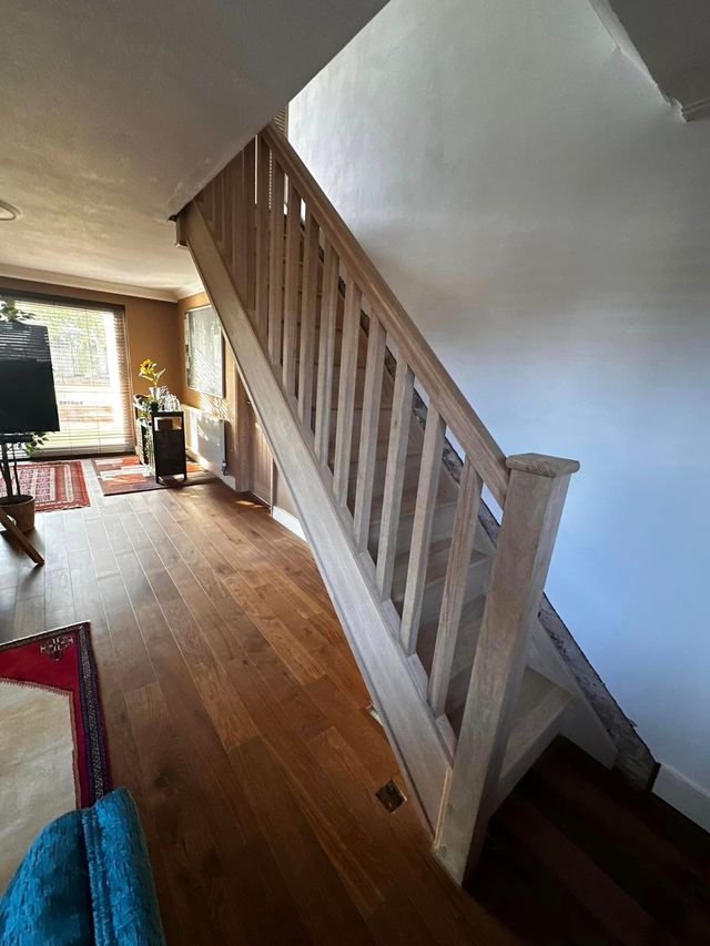 New oak staircase with square oak spindles and handrail above a wooden floor