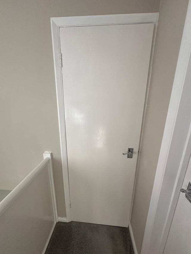 White flush internal door on a landing before replacement