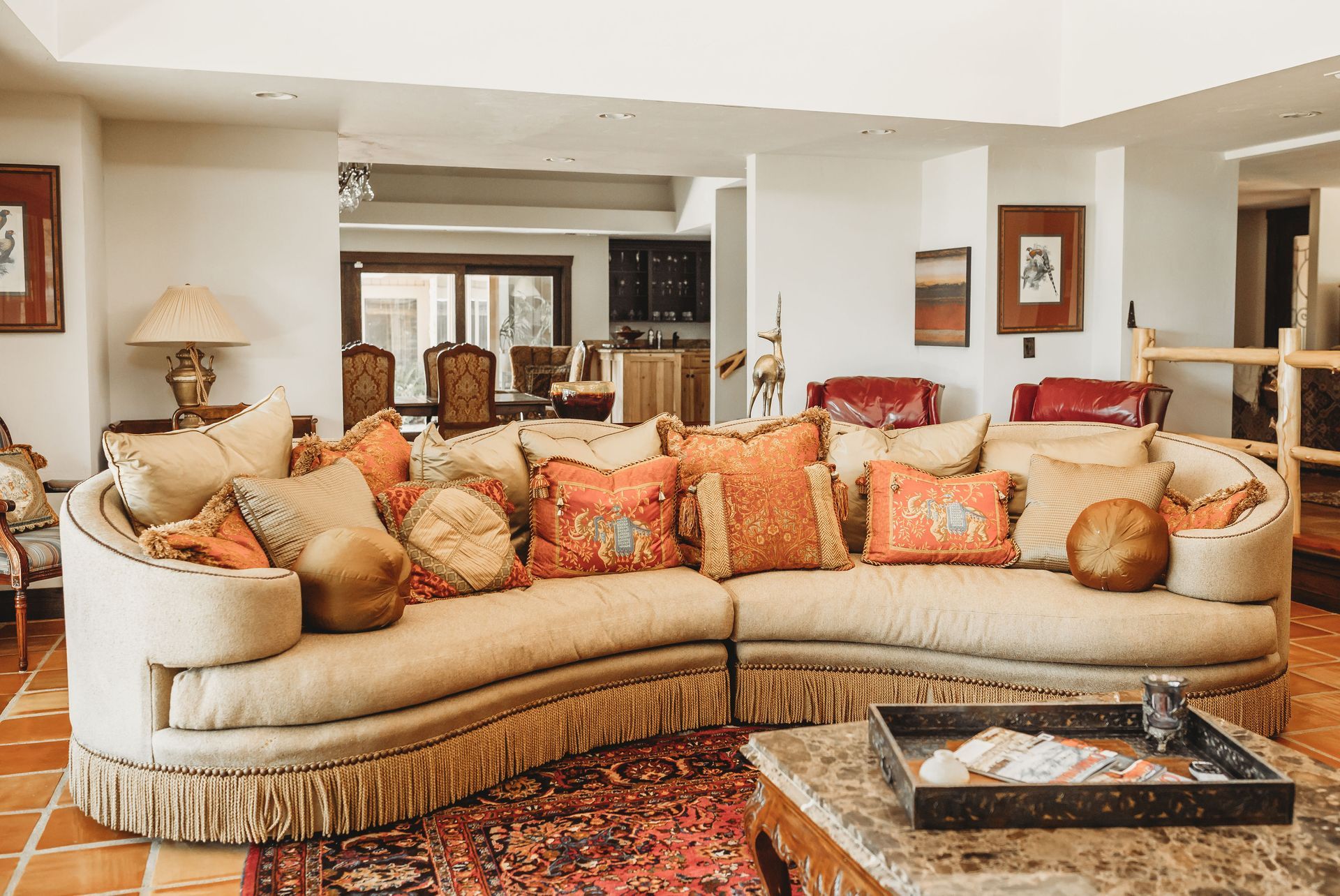 A living room with a large curved couch and a rug.