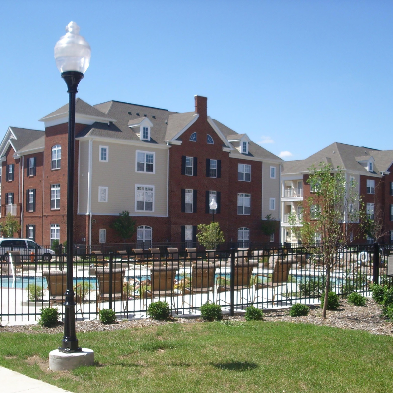 A large brick building with a pool in front of it