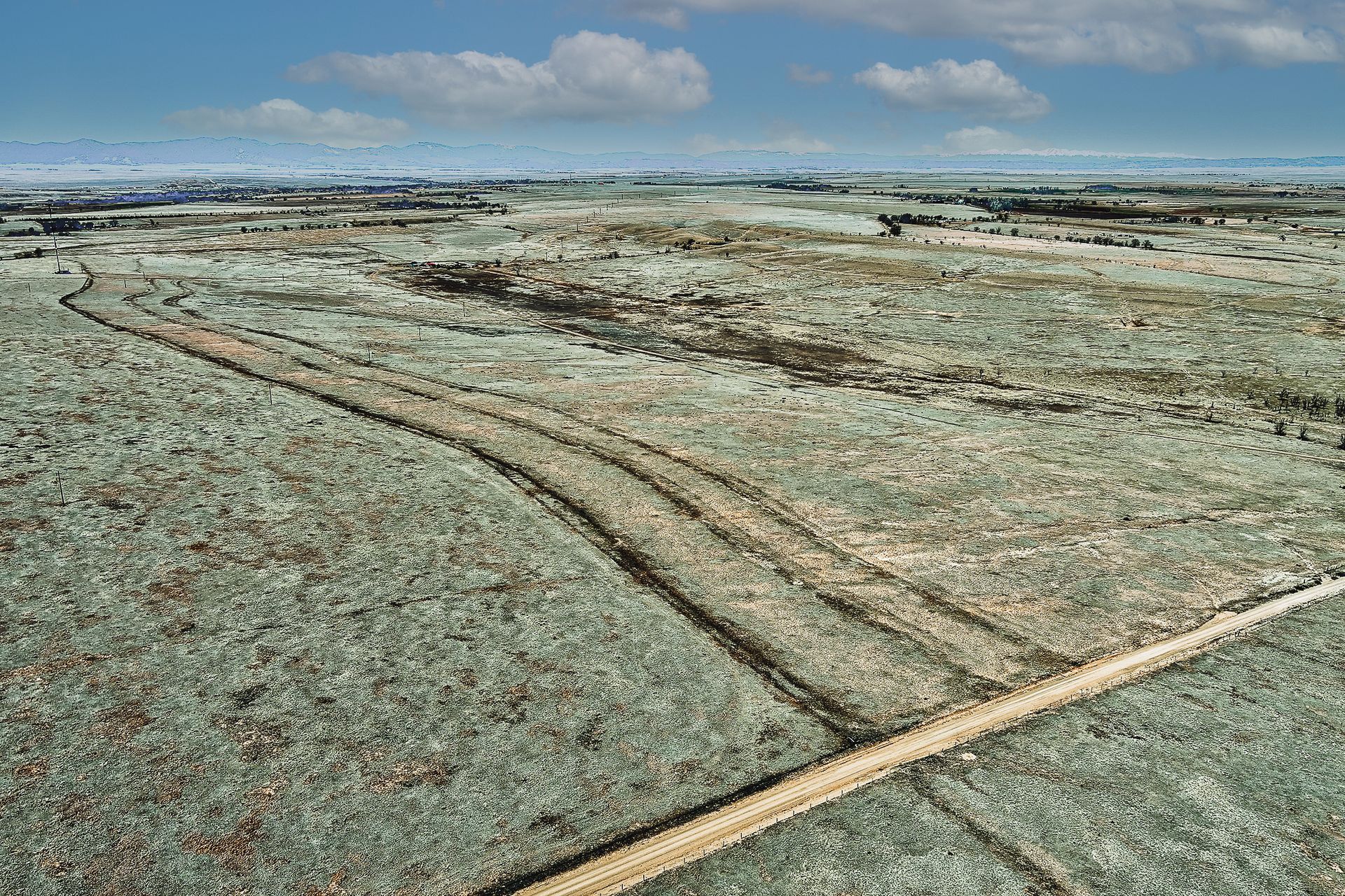 A dirt road in the middle of a grassy field