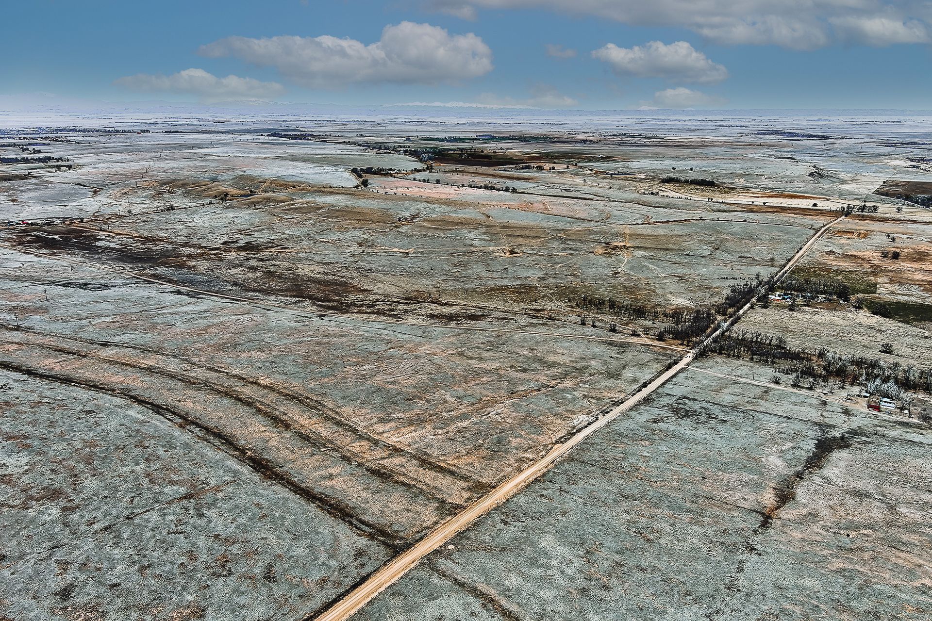 An aerial view of a desert landscape with a blue sky in the background