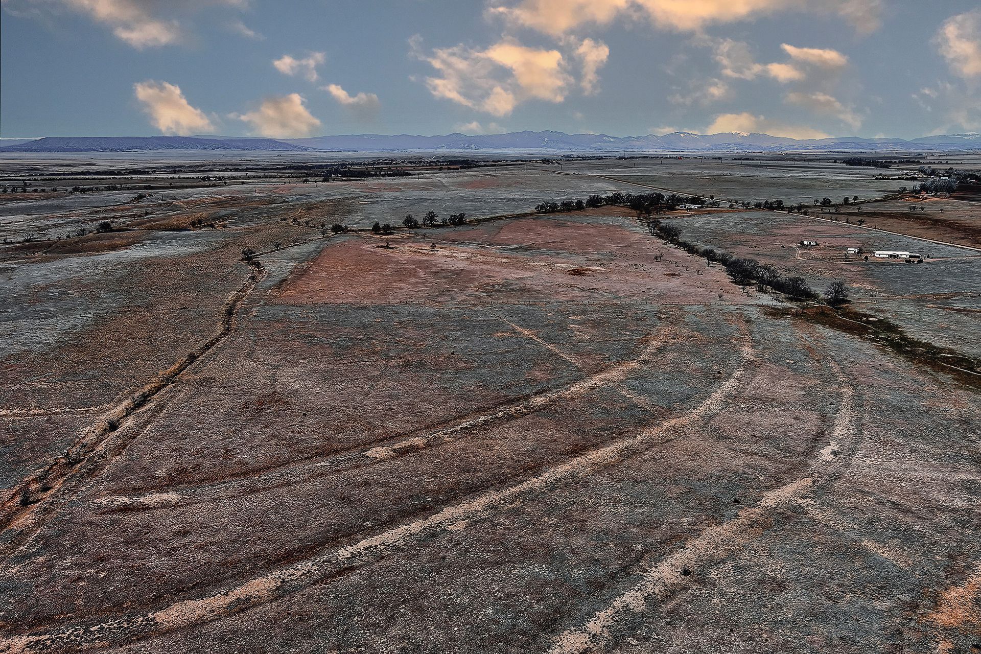 An aerial view of a desert landscape with mountains in the background