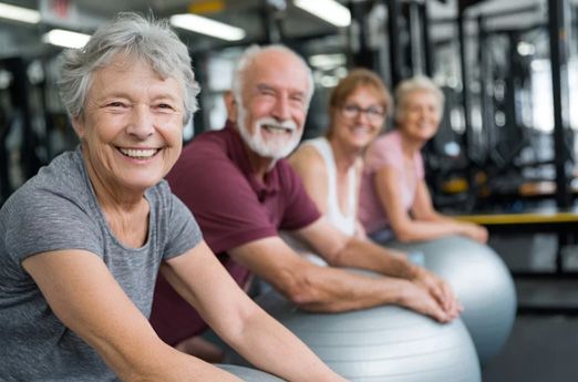 Smiling people exercising on stability balls in a gym
