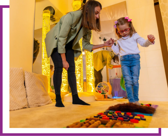 Woman and child playing with colorful blocks in a cozy indoor room with warm lights