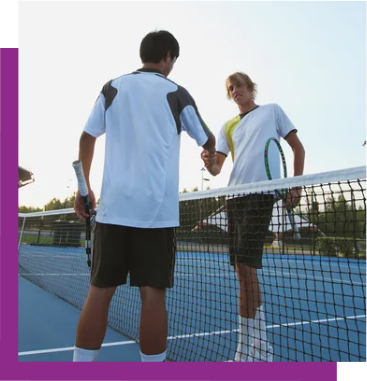 Two tennis players shake hands at the net on a blue outdoor court.