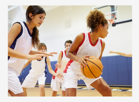 players compete for a basketball on an indoor court during practice.