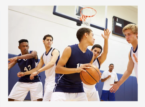 Basketball players battling for possession under the hoop in a gym