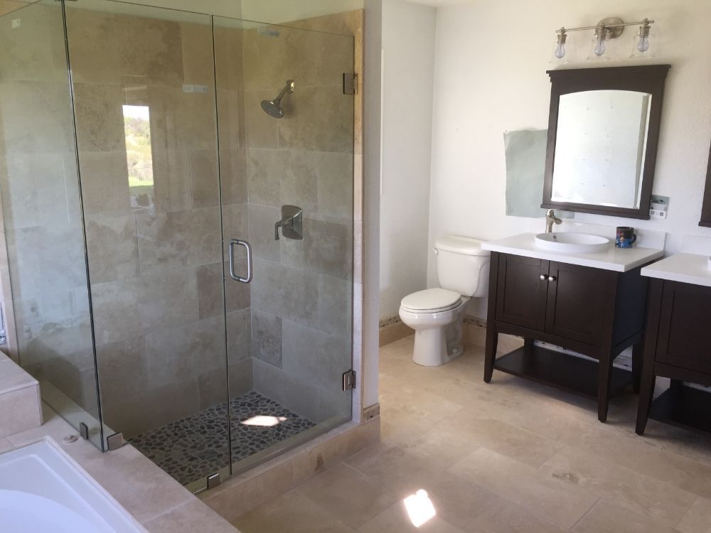 Modern bathroom with glass shower, toilet, and vanity with mirror