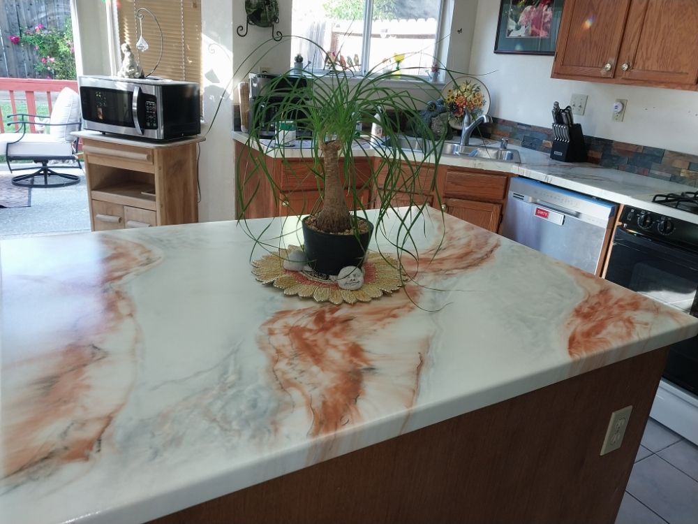 Kitchen island with a potted plant centerpiece and marble-look countertop