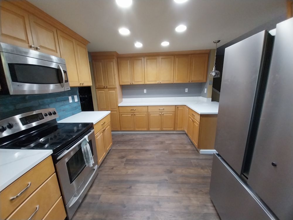 Modern kitchen with wood cabinets, stainless steel appliances, and dark wood flooring
