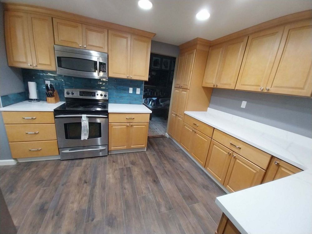 Modern kitchen with wood cabinets, stainless steel appliances, and dark wood flooring