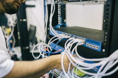 Picture of a computer technician installing cables on a computer.