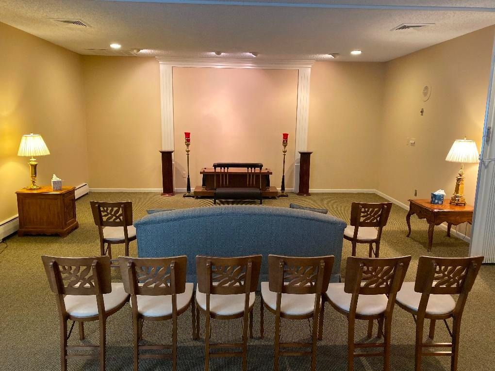 Funeral home chapel with casket, chairs, and altar area.