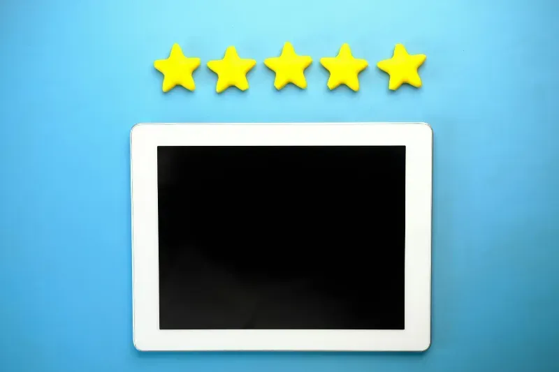 A tablet with five yellow stars around it on a blue background