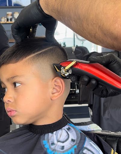 A young boy is getting his hair cut by a barber.
