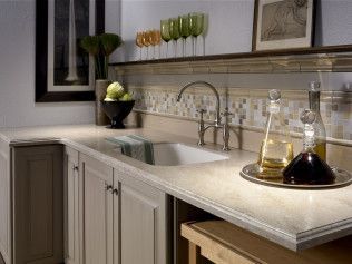 A kitchen with a sink , cabinets , and a tray of bottles on the counter.