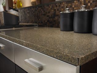 A kitchen counter with a granite counter top and stainless steel drawers.