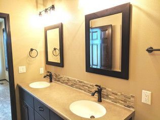 A bathroom with two sinks and two mirrors.