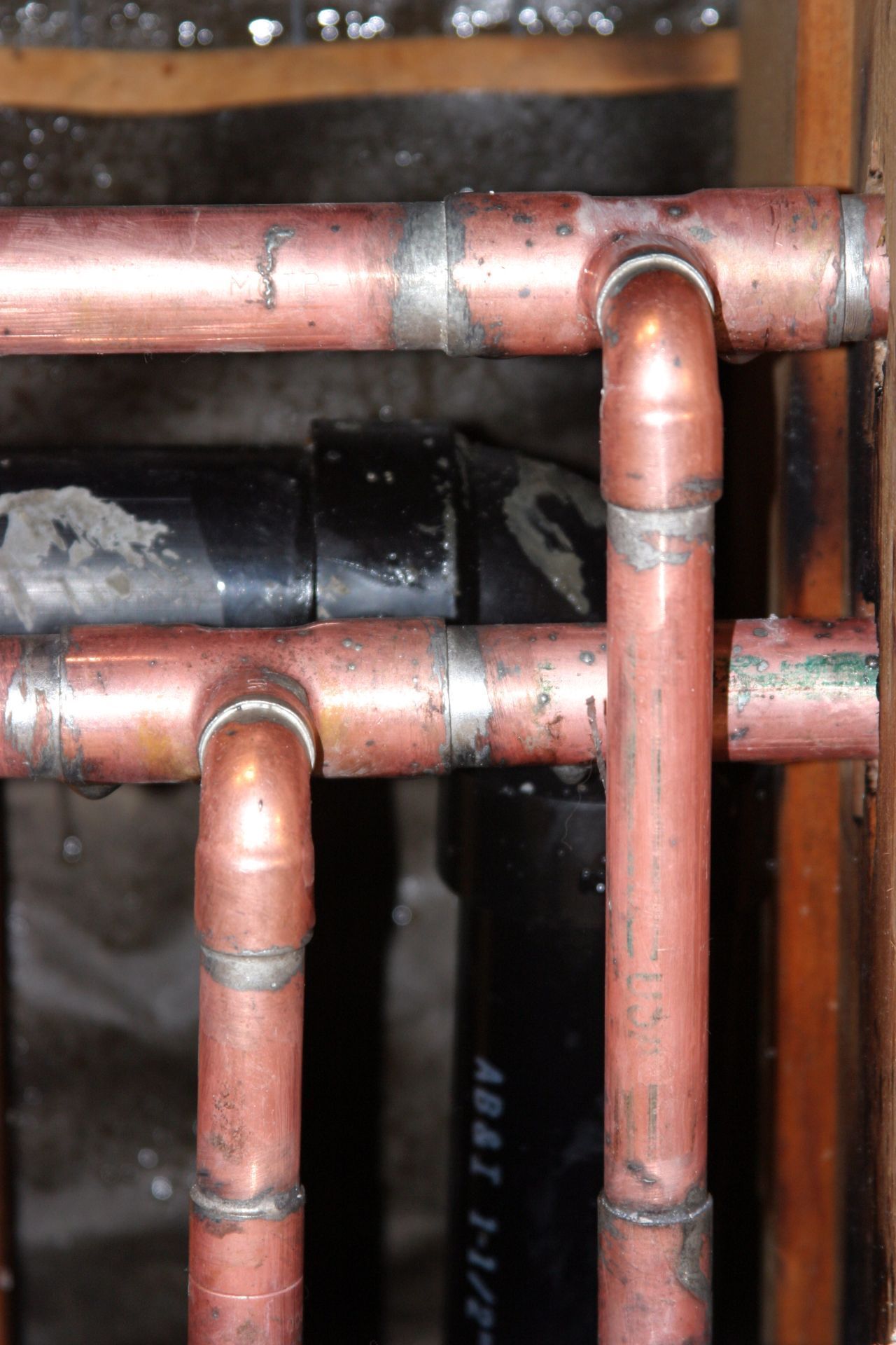 Copper pipes and fittings connected together, water visible.