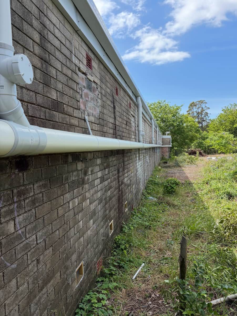 A Low-angle View of a Brick Building Exterior — Crystal Clear Plumbing & Roofing in Wollongong, NSW