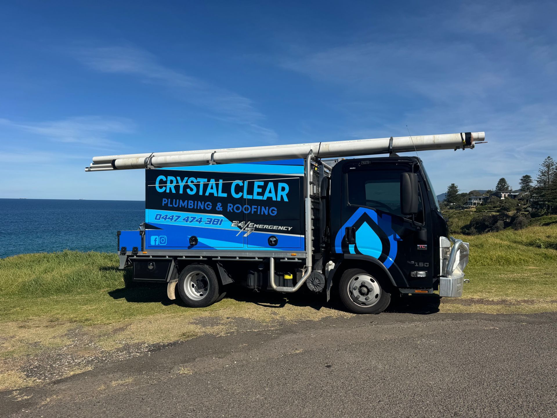 Blue and black Crystal Clear delivery truck parked on a road, side view — Crystal Clear Plumbing & Roofing in Wollongong, NSW