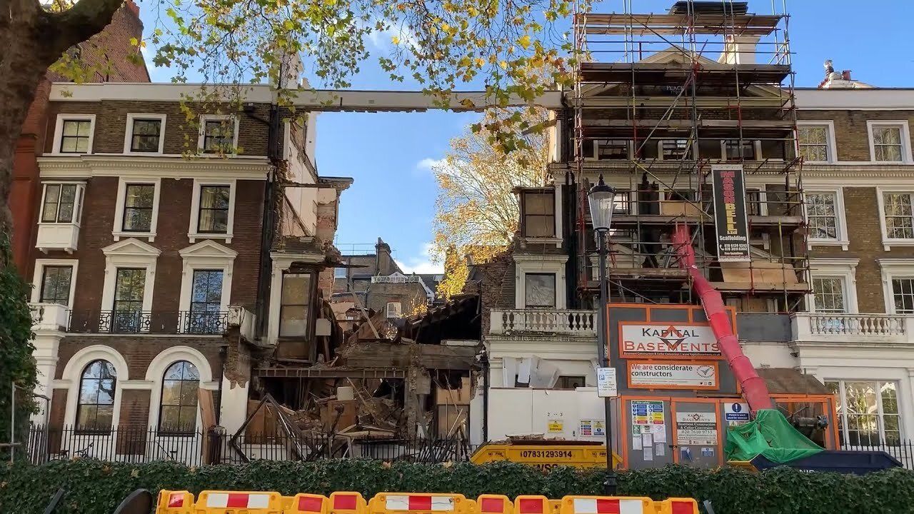 a brick building with graffiti on the side of it is being demolished .