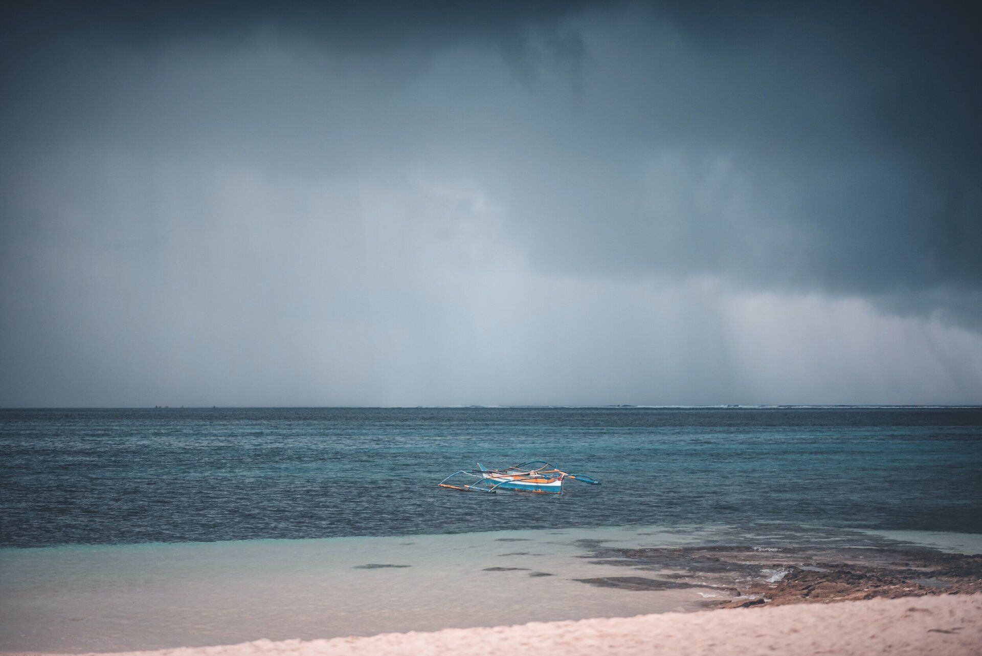 a person is swimming in the ocean on a cloudy day .