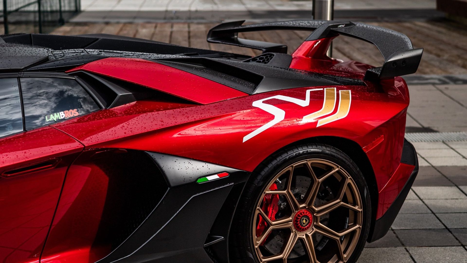 a red lamborghini aventador is parked on a sidewalk .