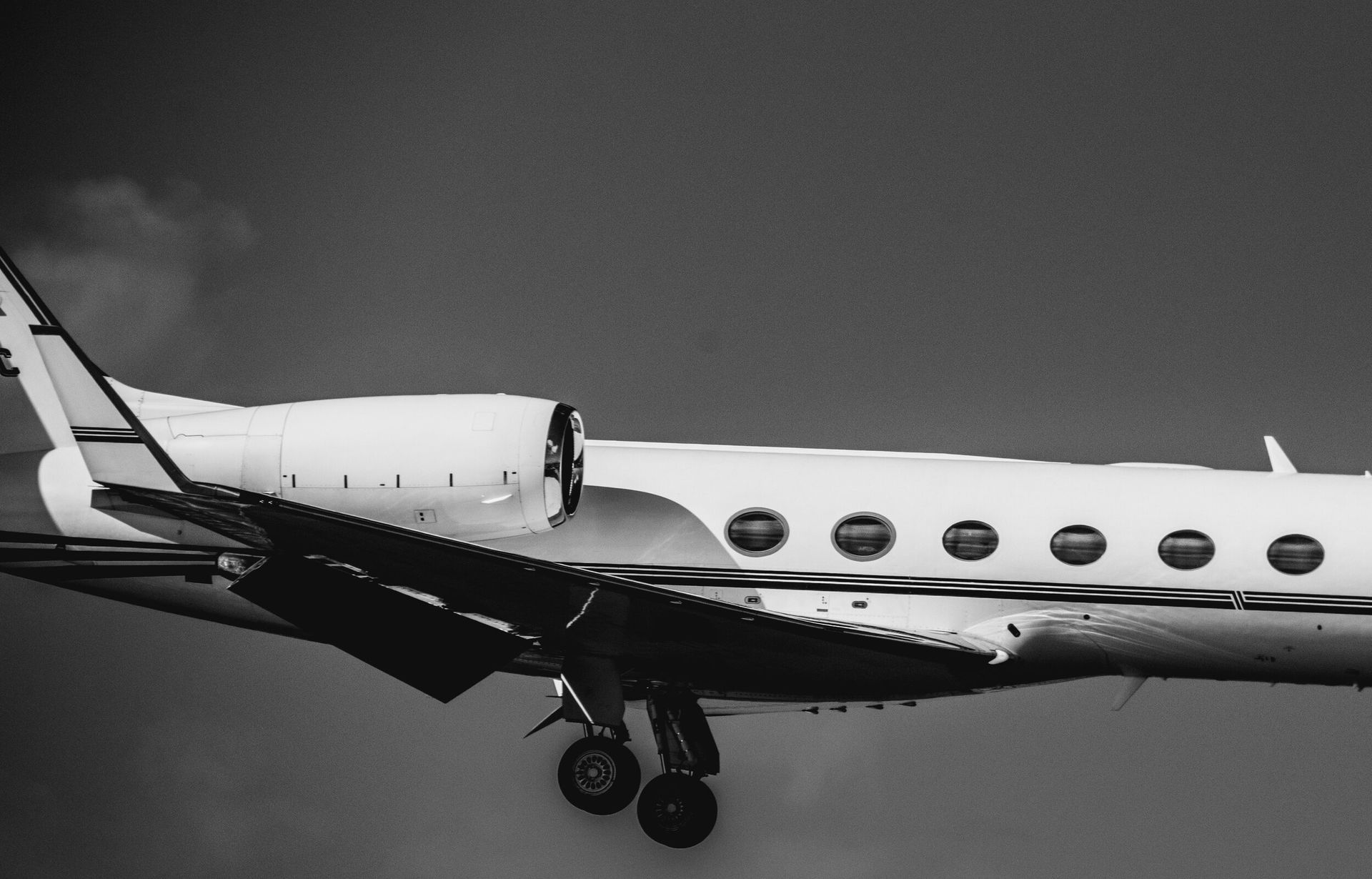 a black and white photo of a plane flying in the sky