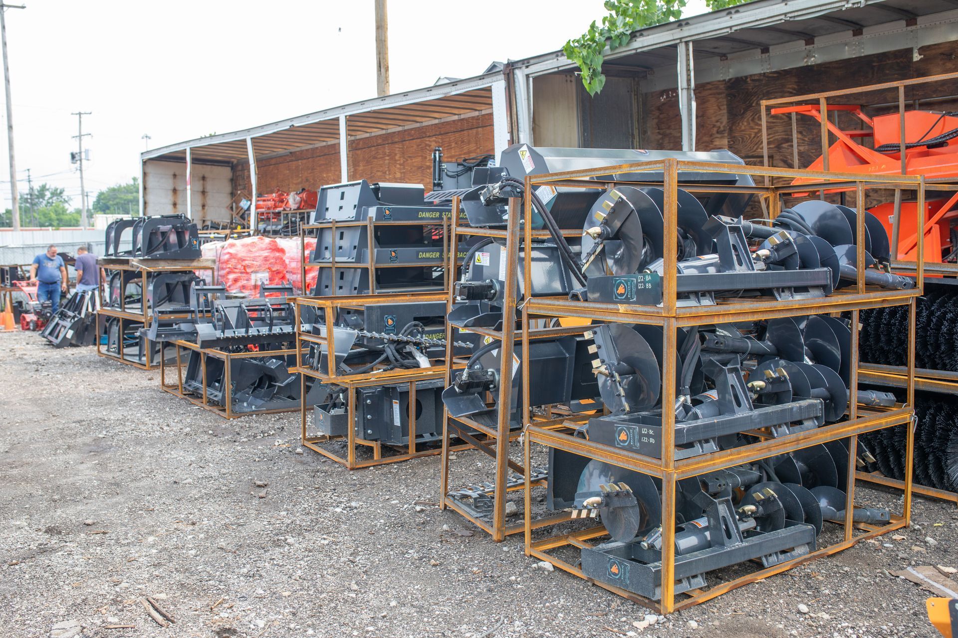 Snowblower components stacked on metal shelving outdoors.